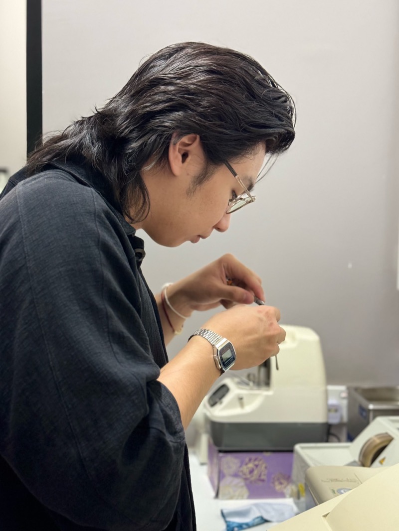 Craftsperson fine-tuning a pair of glasses at the workbench
